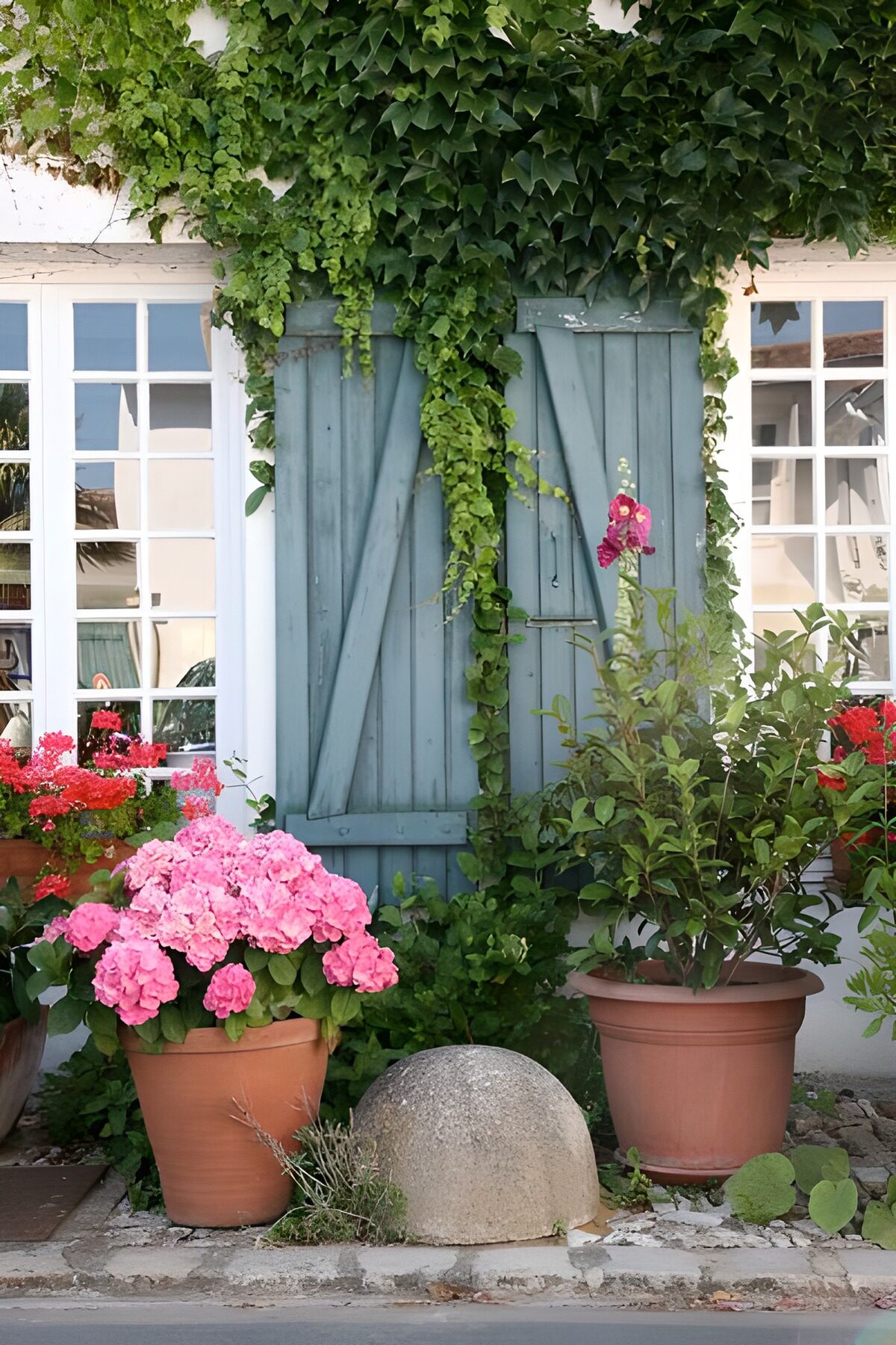 Blauwe luiken tussen groen en bloemen