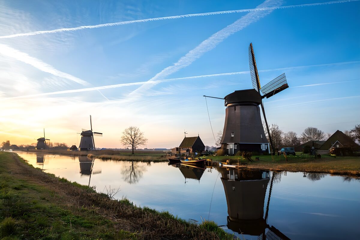 Windmolens aan het kanaal in laag zonlicht