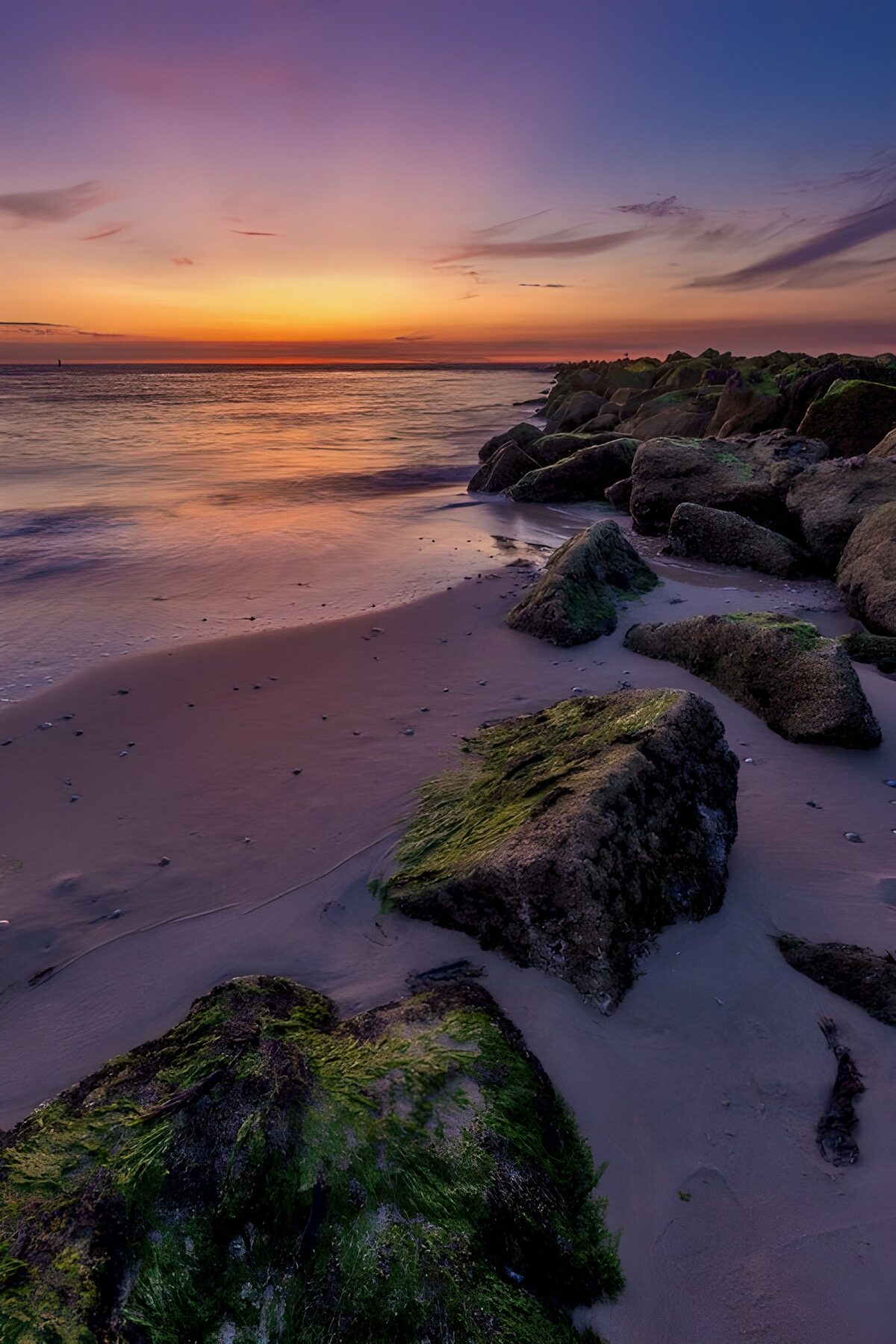 Rotsen op het strand bij zonsondergang