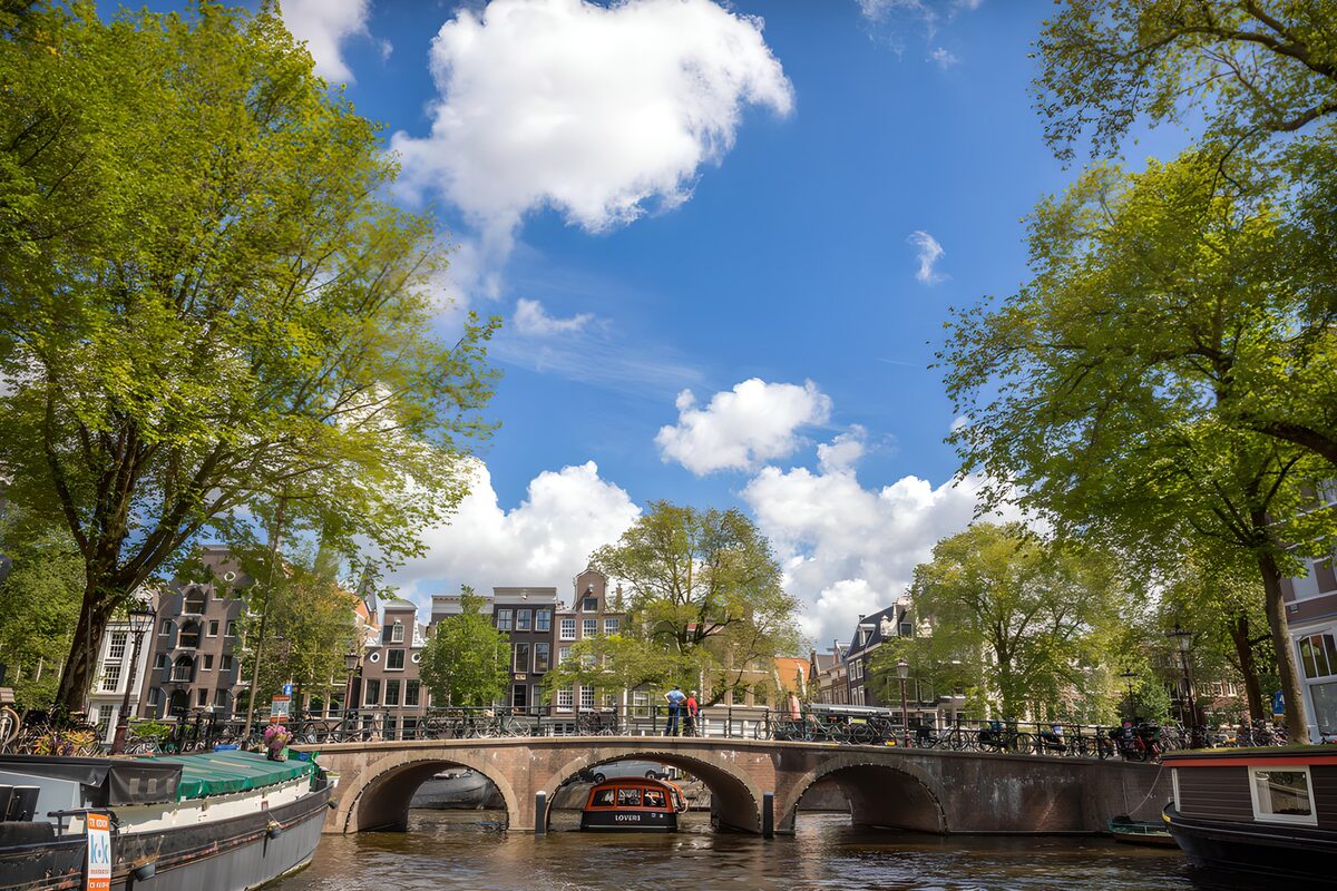 Gracht met boogbrug in de zon