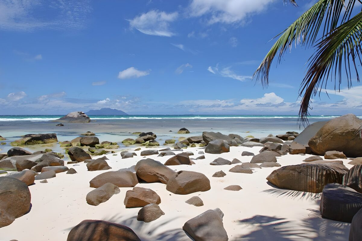 Wit zand, rotsen en turquoise zee