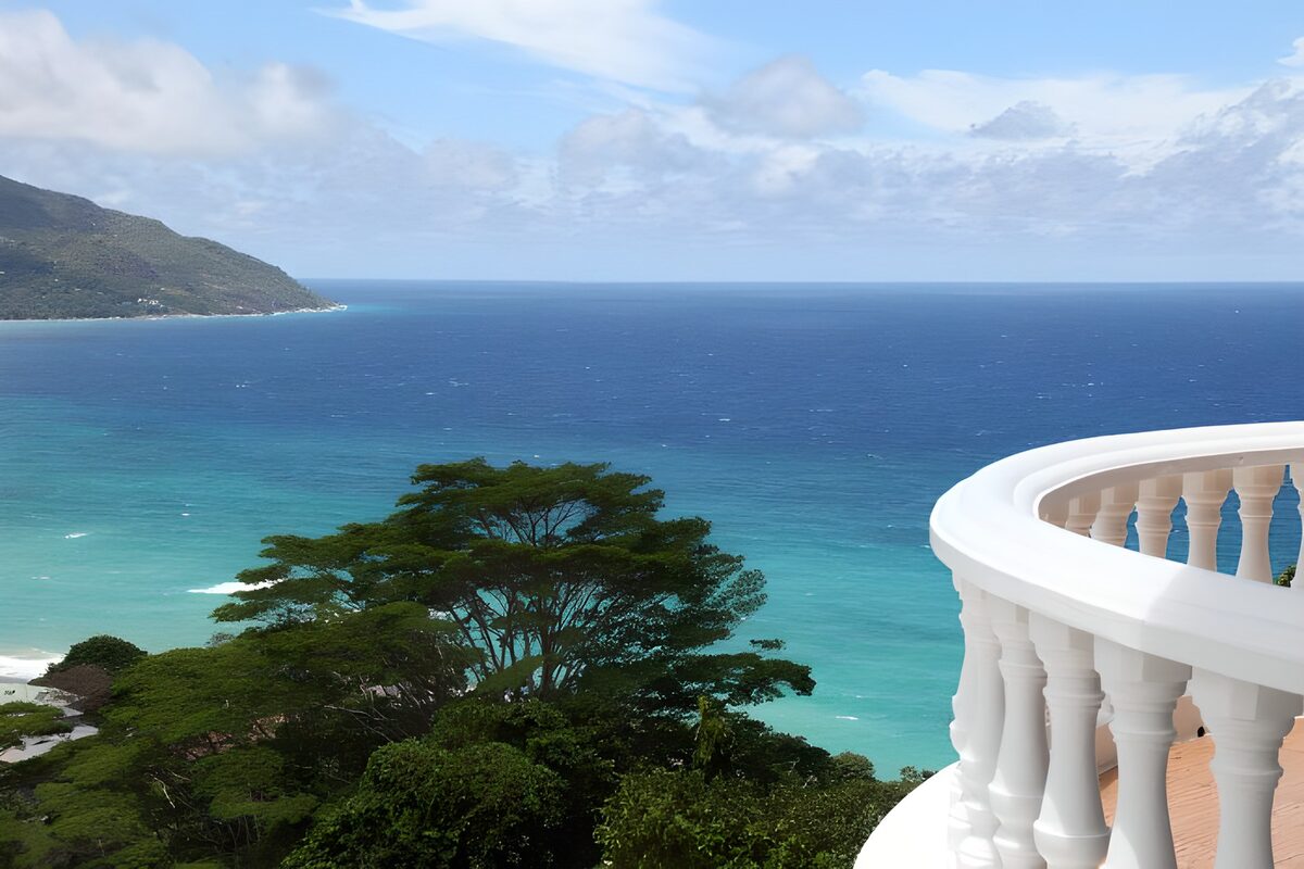 Wit balkon boven een turquoise baai