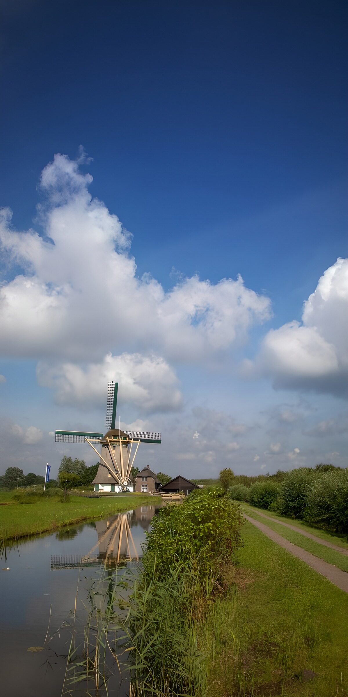 Windmolen aan de sloot onder stapelwolken