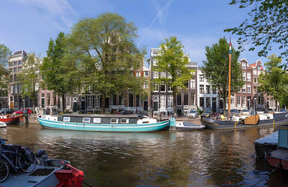 Turquoise woonboot voor oude grachtenpanden