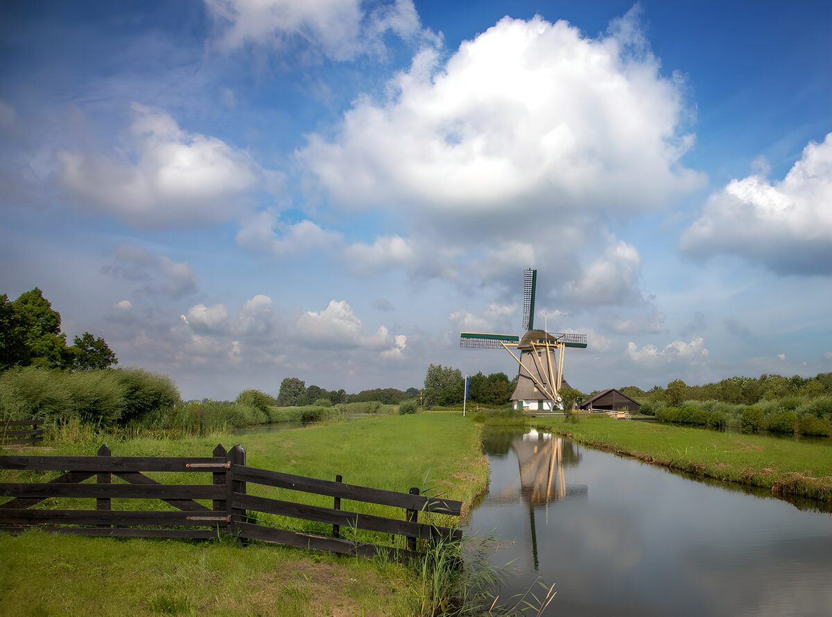 Windmolen aan het water in de groene wei
