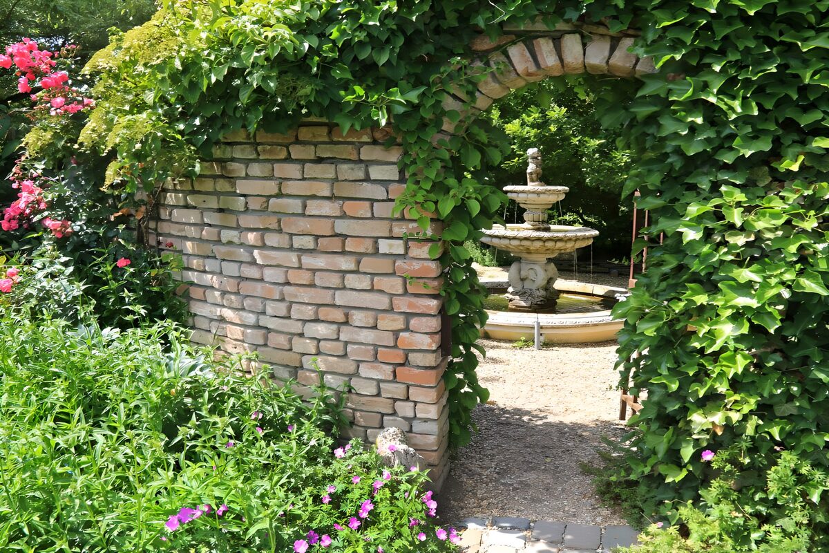 Groene tuinboog met fontein