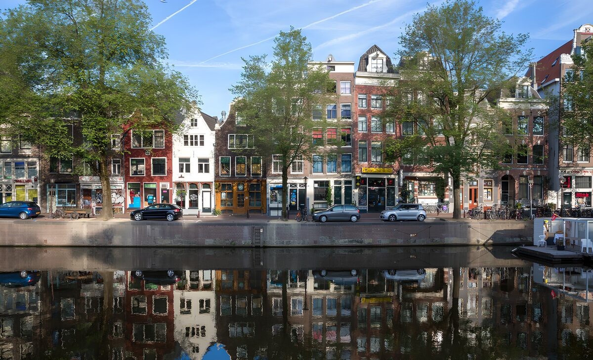 Zonnige grachtenpanden met spiegelbeeld