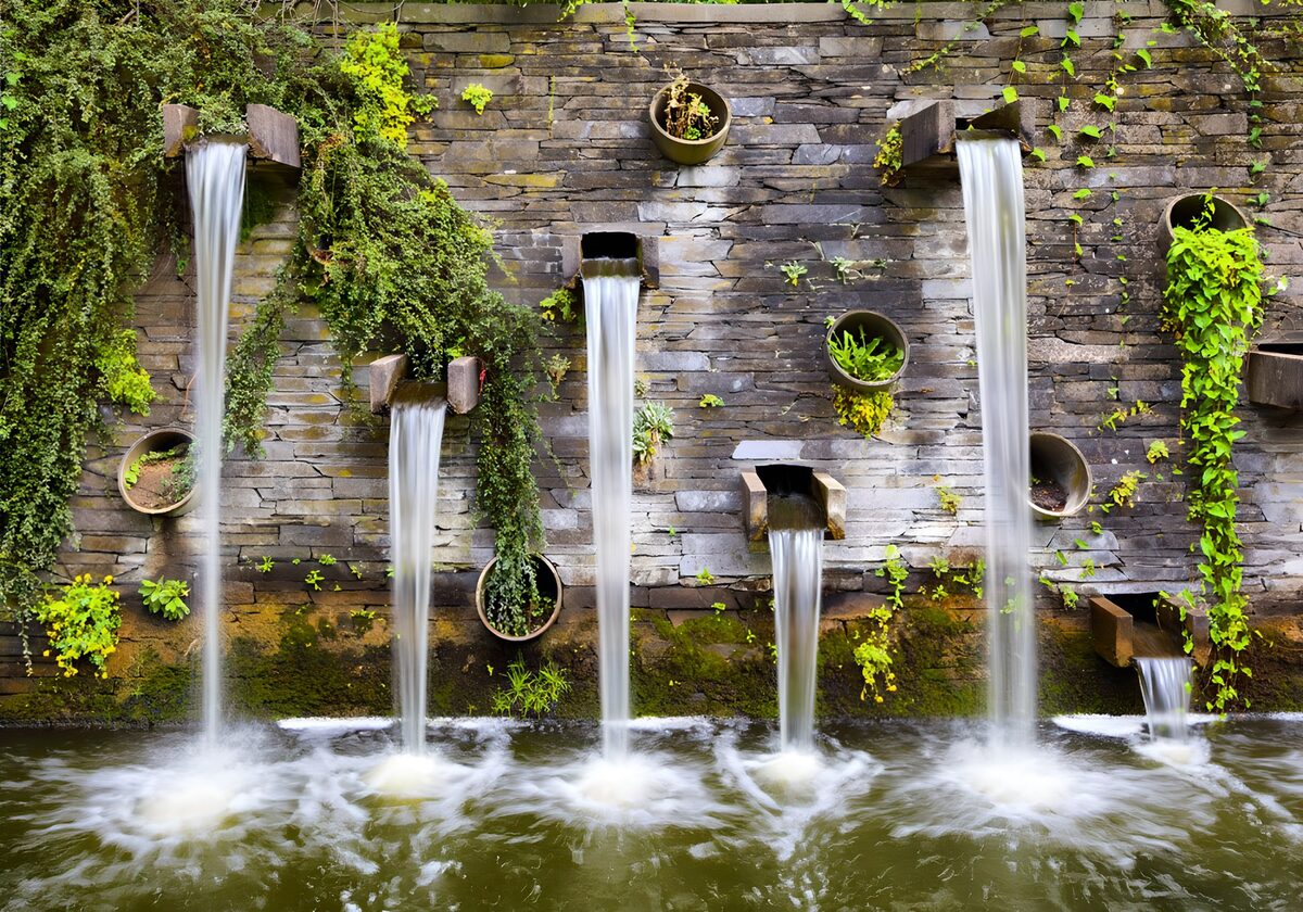 Stenen watermuur vol groen