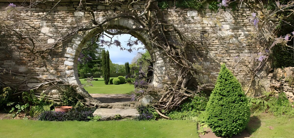 Oude tuinmuur met groene doorkijk