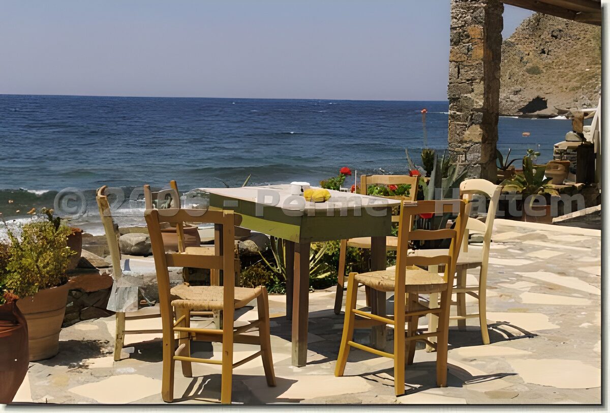 Terras met houten stoelen aan zee
