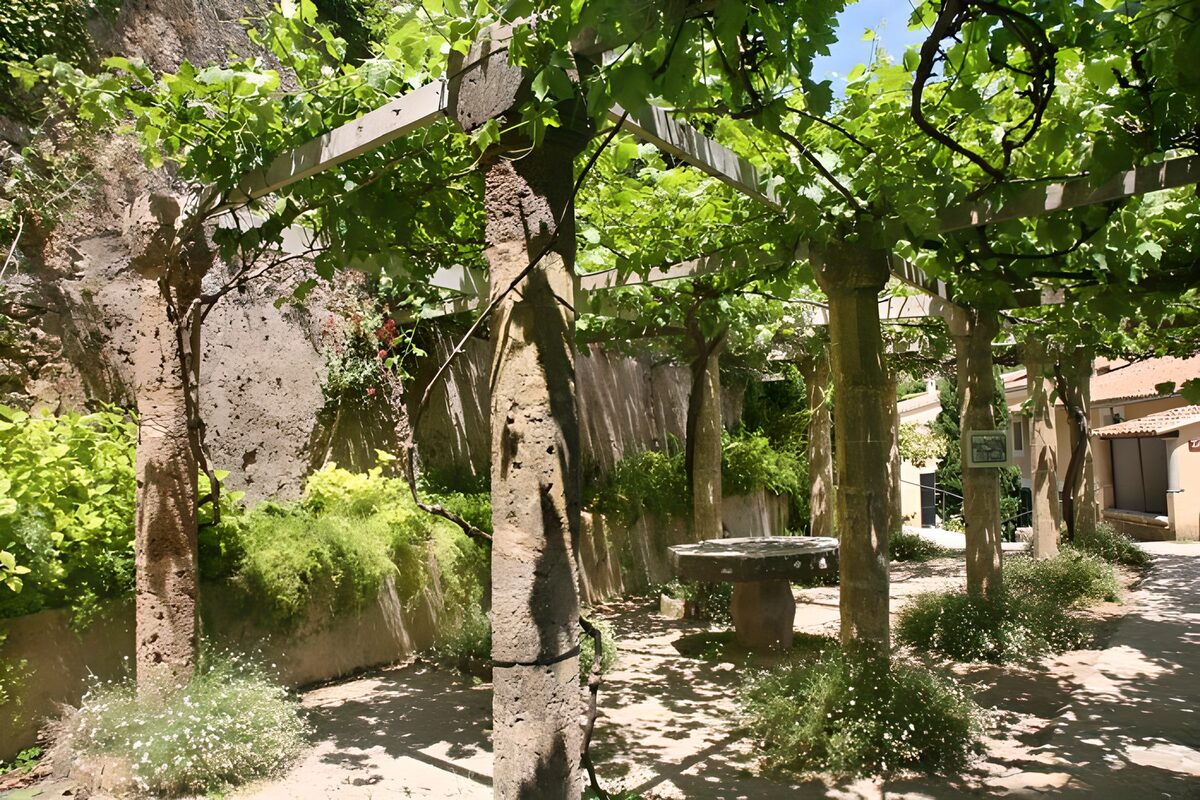 Pergola met groen en stenen zuilen
