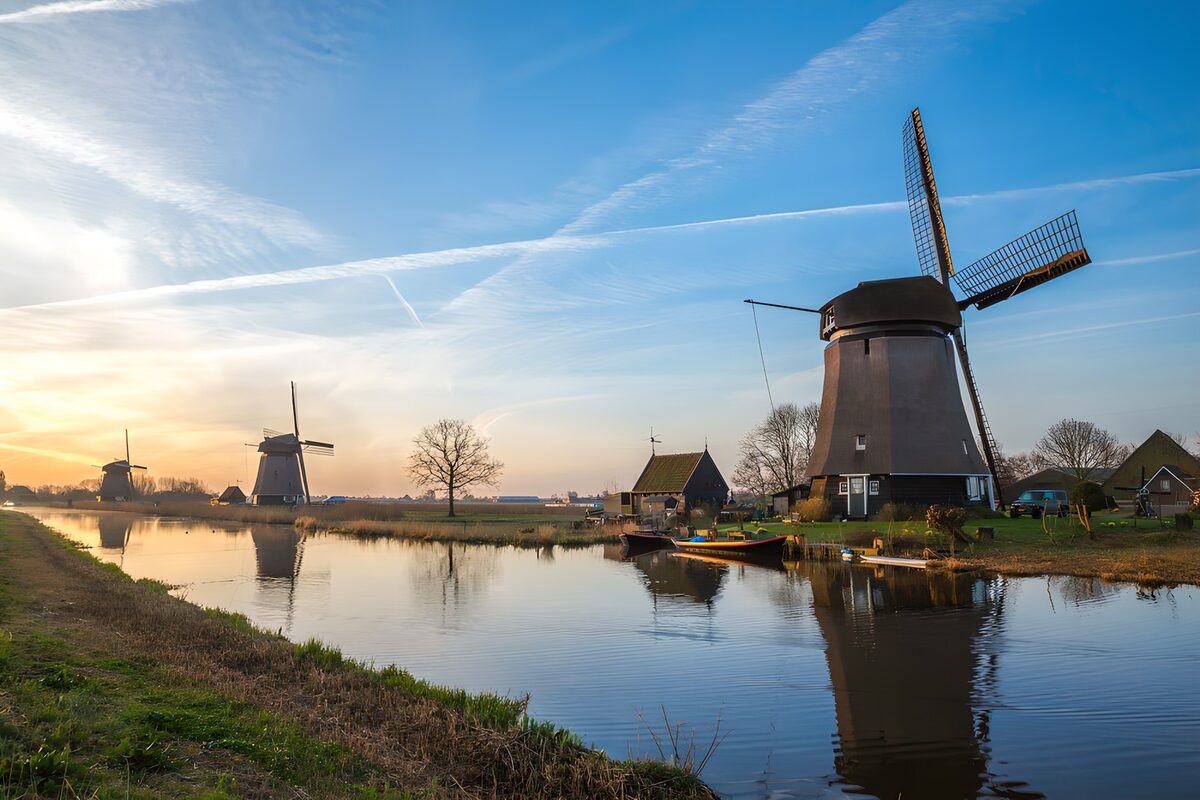 Windmolens aan het water in avondlicht