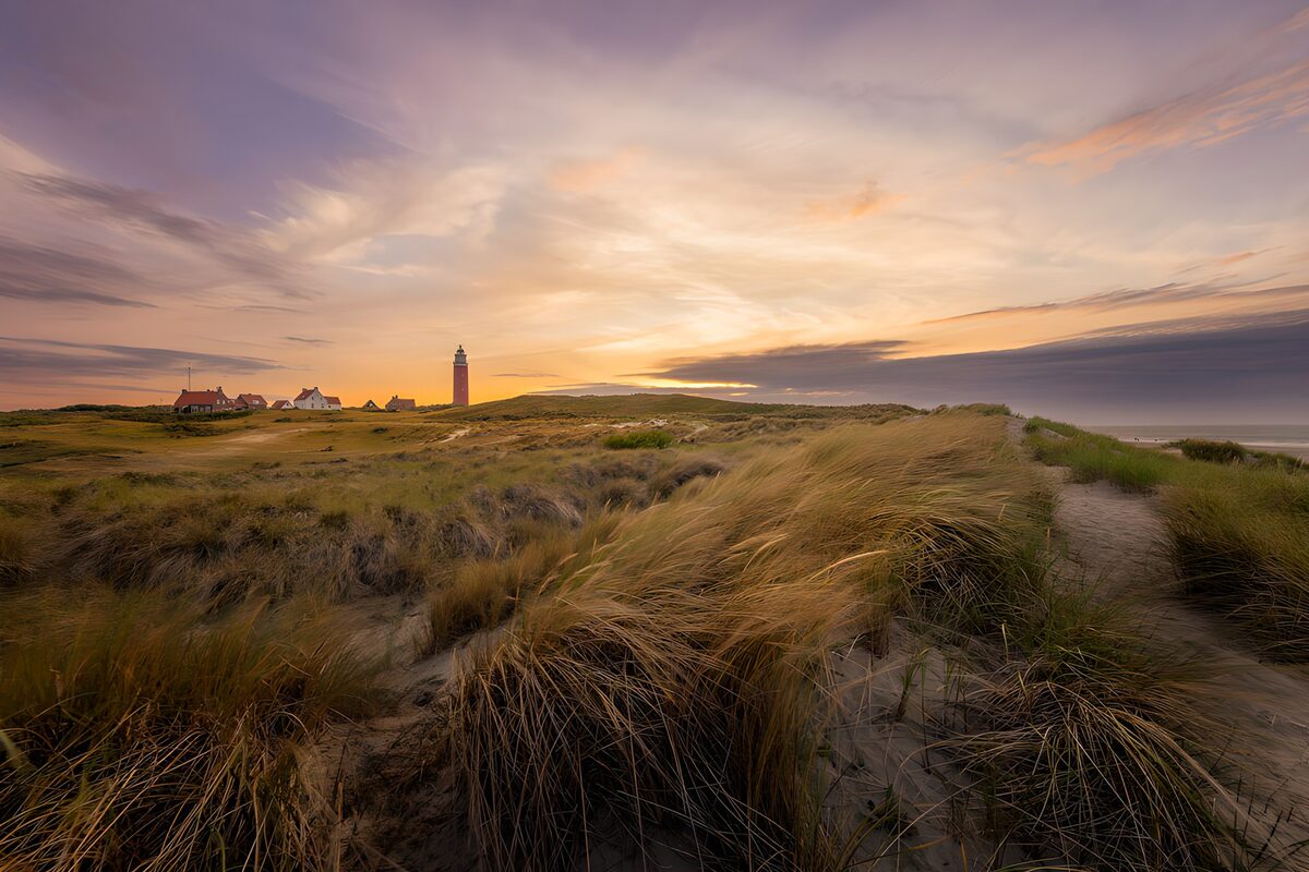 Duinen en vuurtoren bij zonsondergang