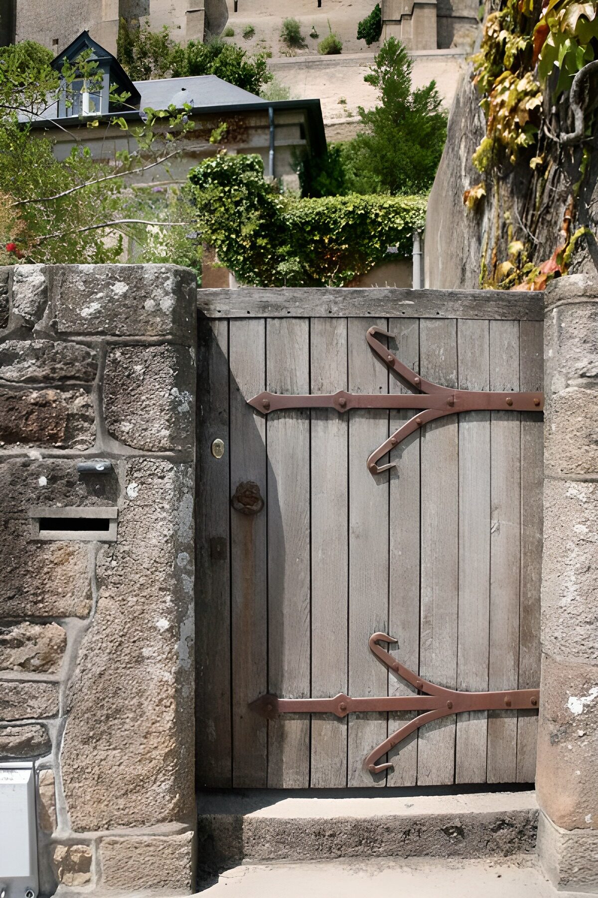 Houten tuinpoort tussen ruwe stenen