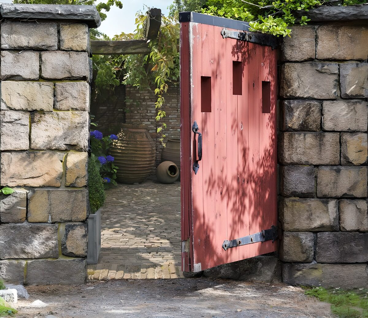 Rode tuinpoort in een stenen muur