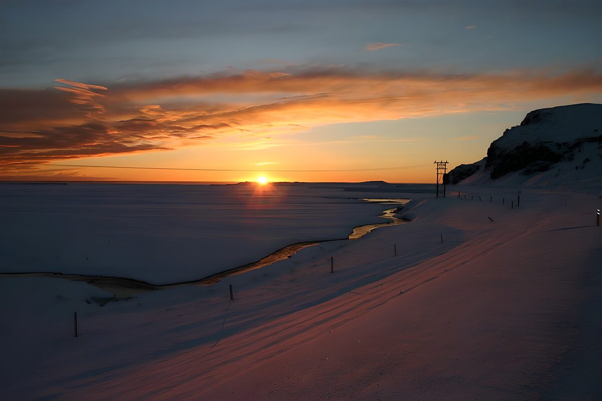 Winterkust onder een oranje avondlucht