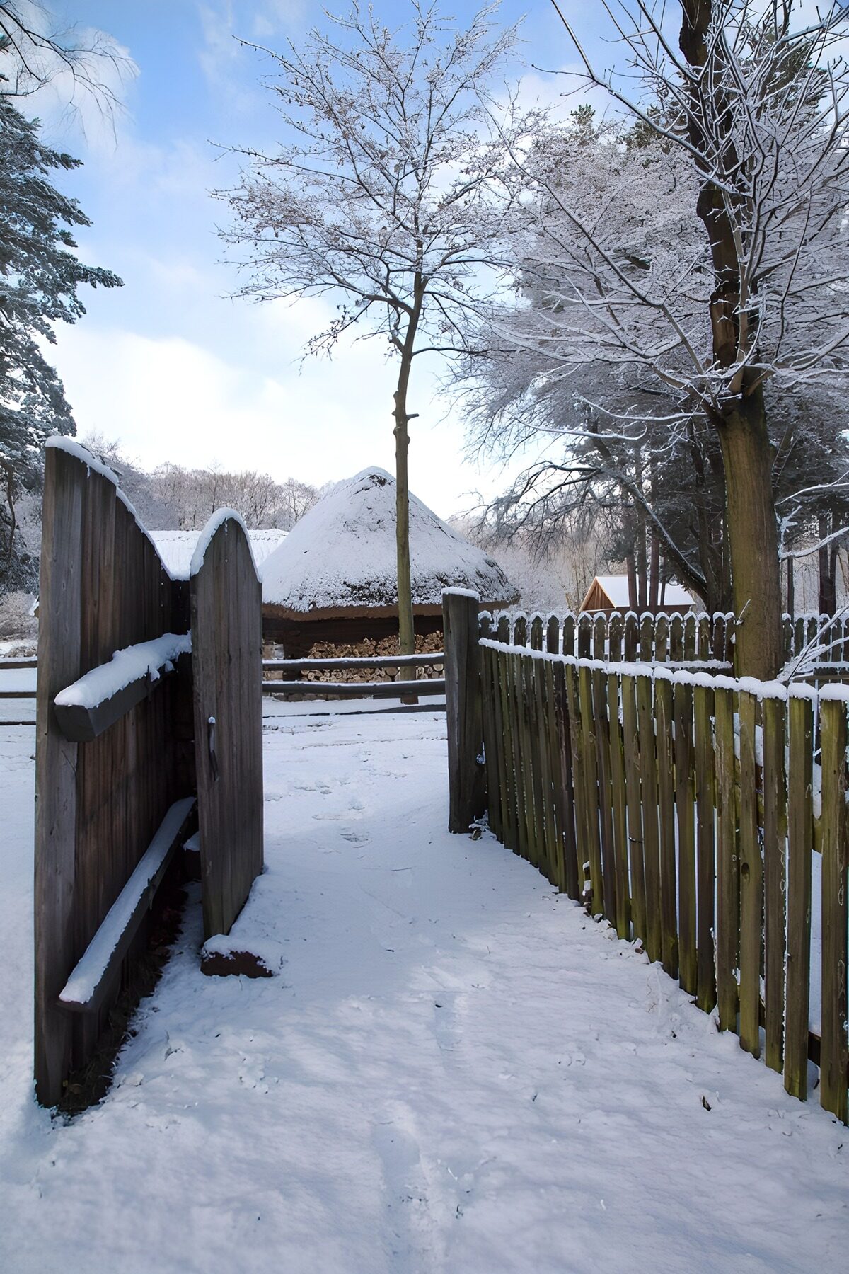 Besneeuwde poort naar een rond huisje