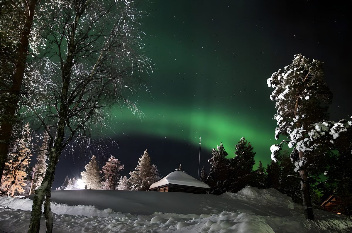 Noorderlicht boven een besneeuwde hut