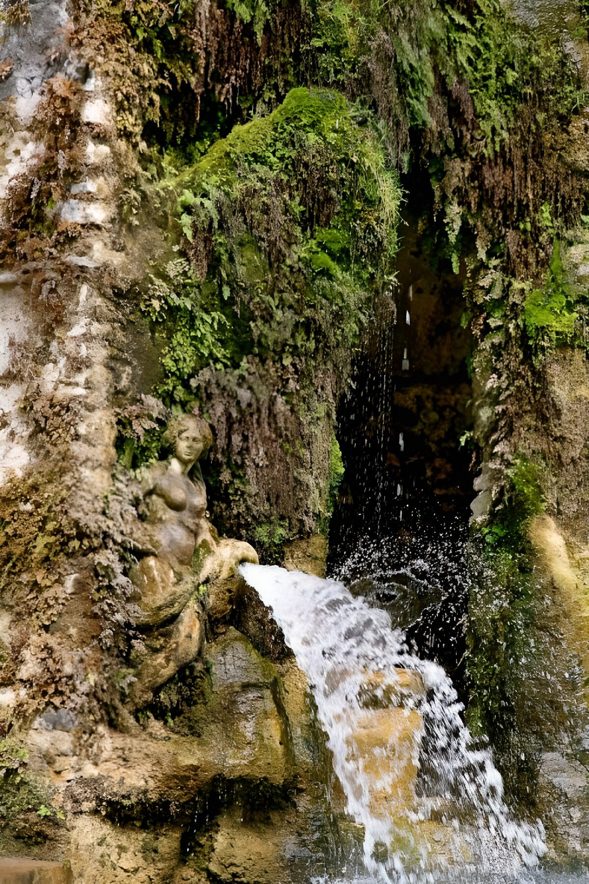 Mossige fontein met vrouwenbeeld