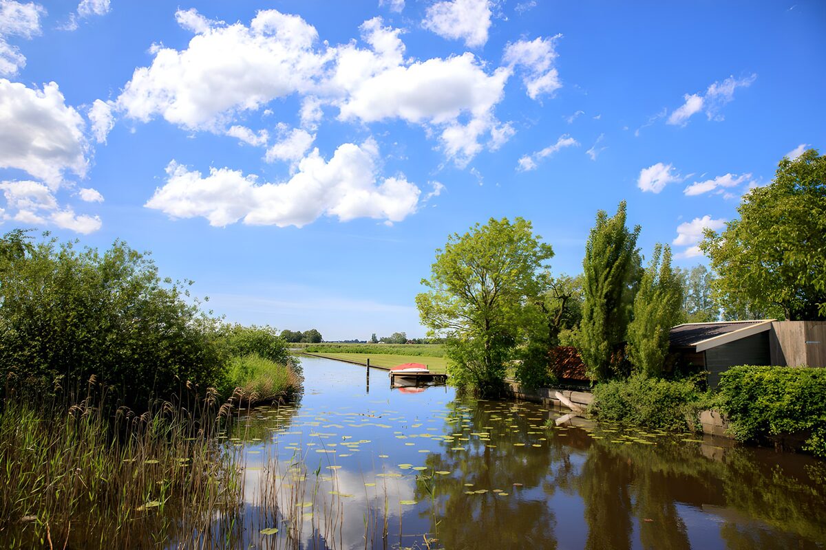 Landelijk kanaal met boot en waterlelies