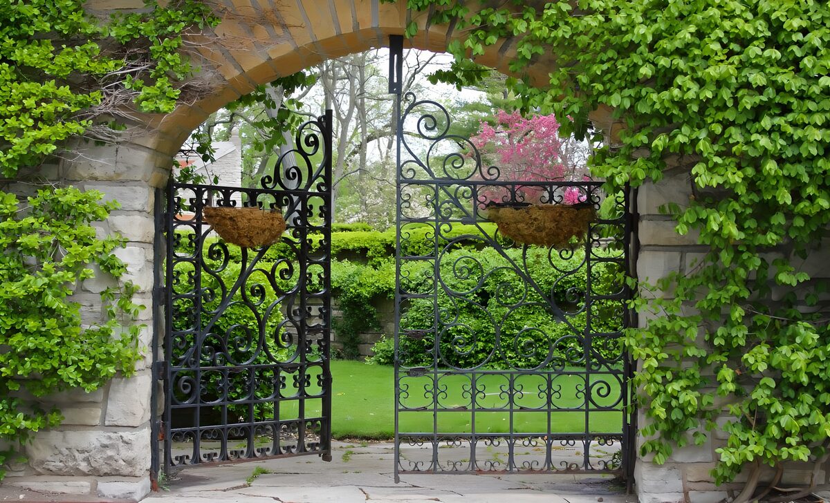 Smeedijzeren tuinpoort in het groen