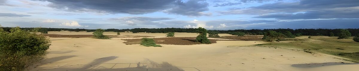 Zandduinen onder een weidse wolkenlucht