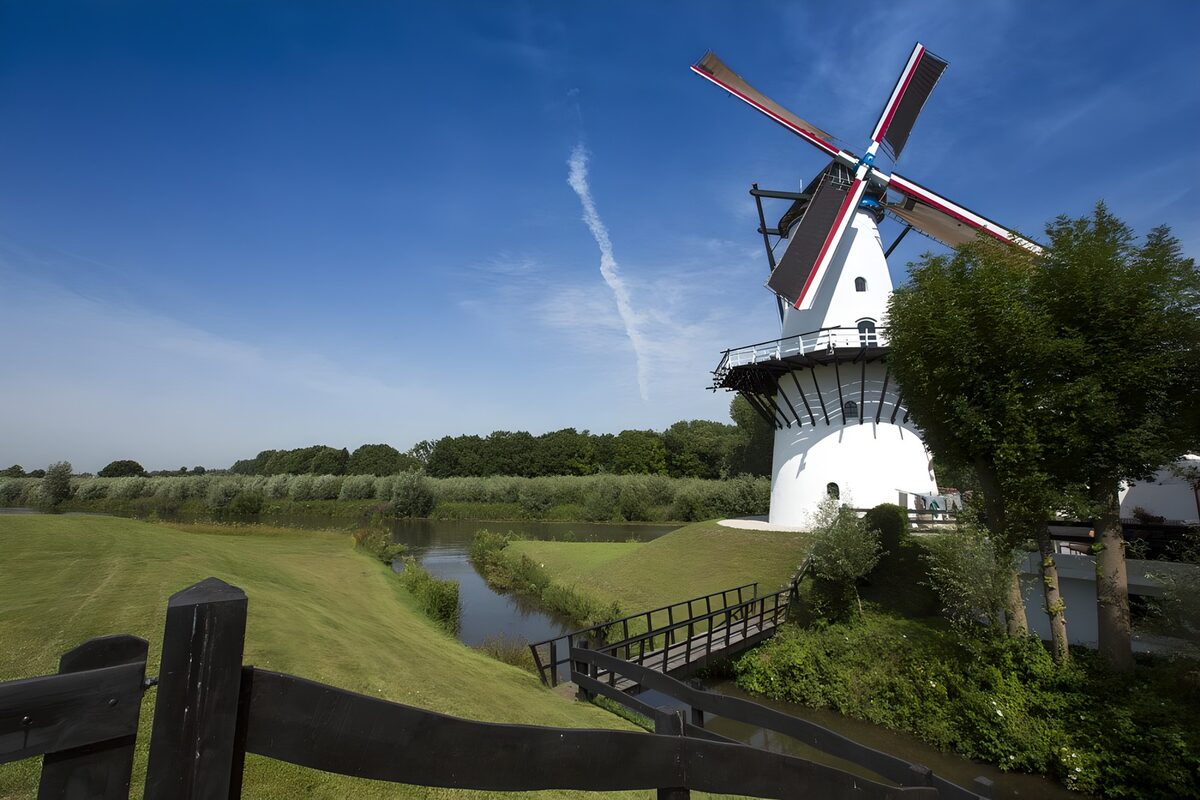 Witte windmolen onder een blauwe hemel