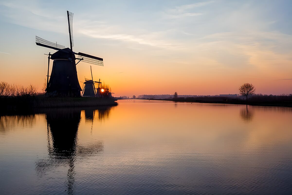 Molens aan het water bij zonsondergang
