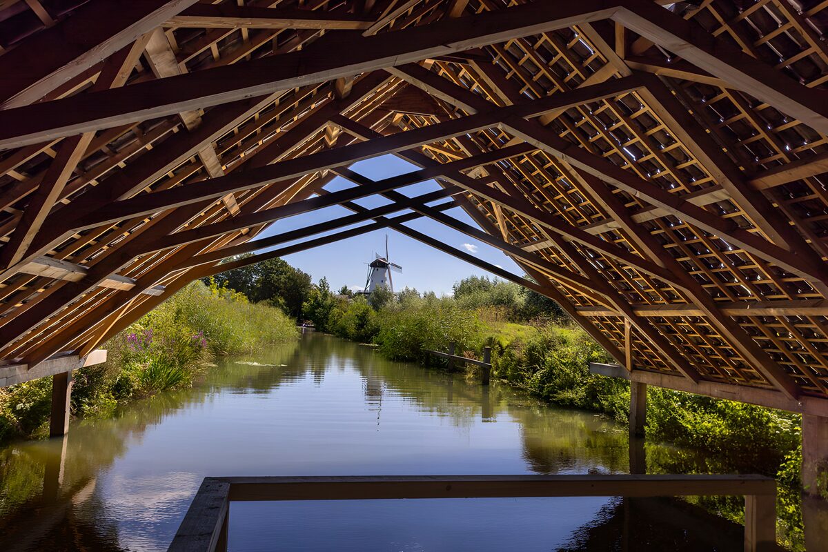 Molen aan het water onder een houten dak