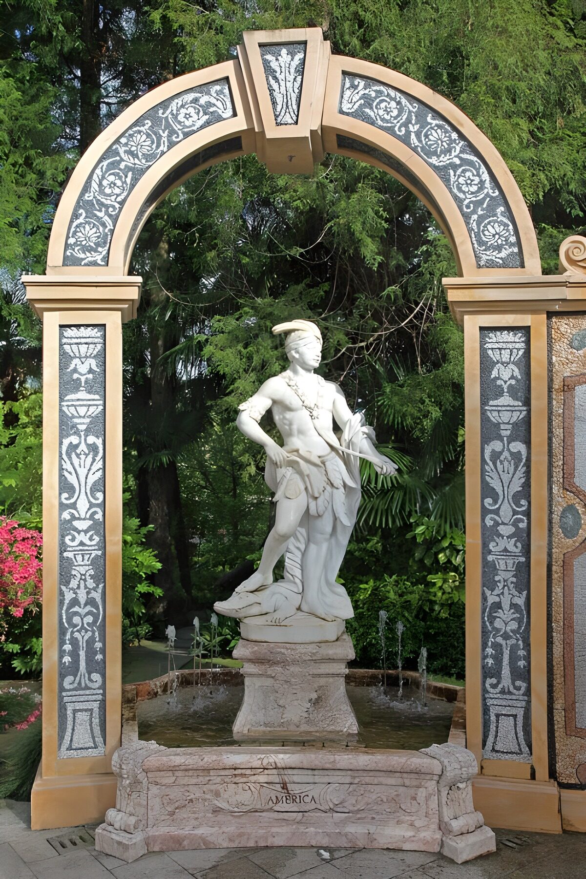 Standbeeld en fontein onder een sierboog