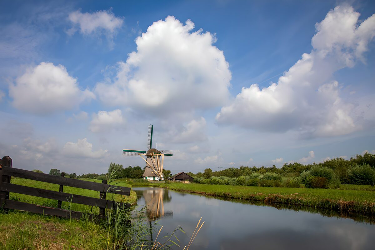 Molen aan het water onder stapelwolken