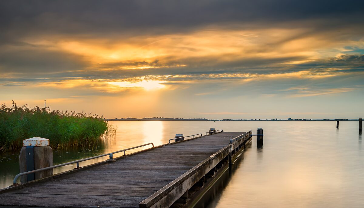 Steiger aan het meer bij zonsondergang