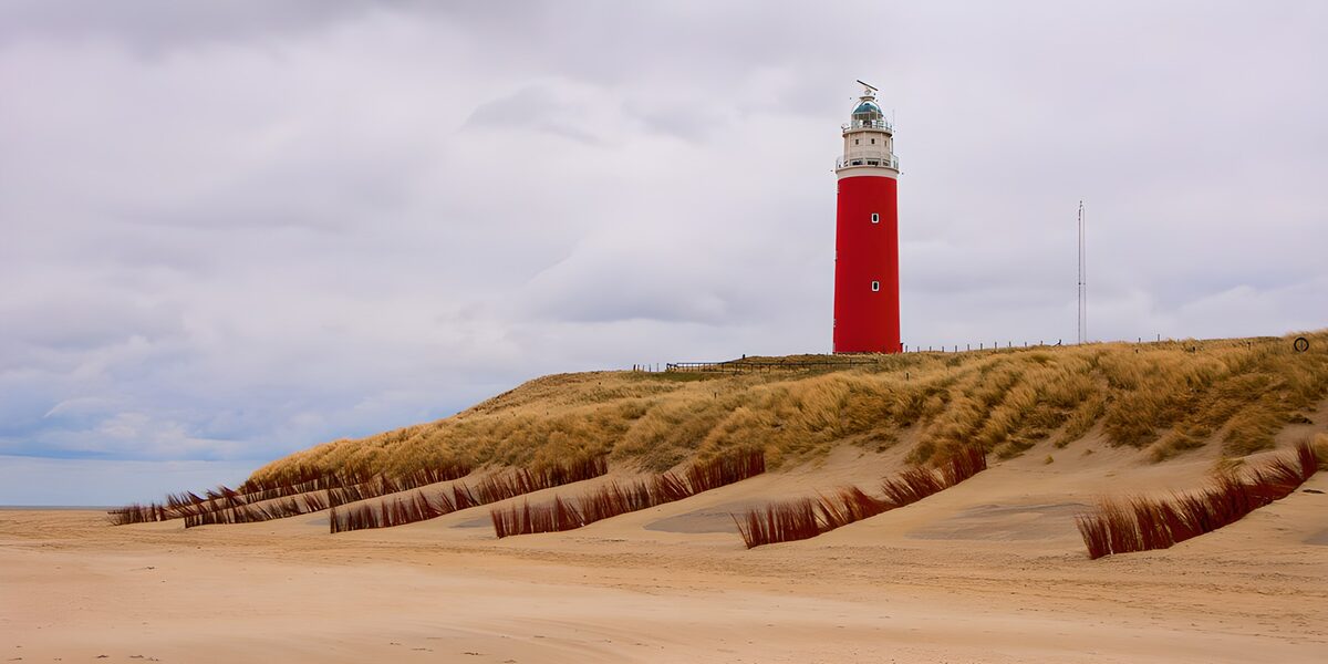 Rode vuurtoren boven de zandduinen