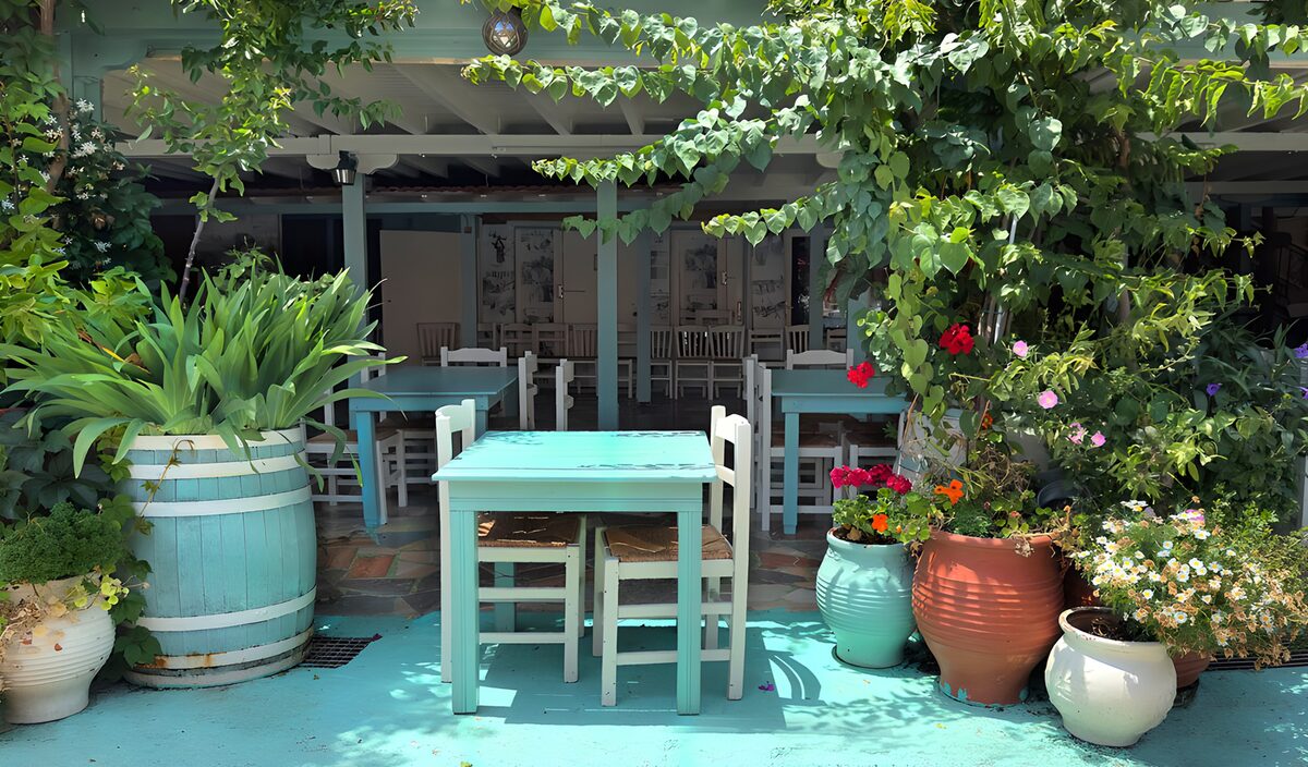 Turquoise terras met tafels en bloemen