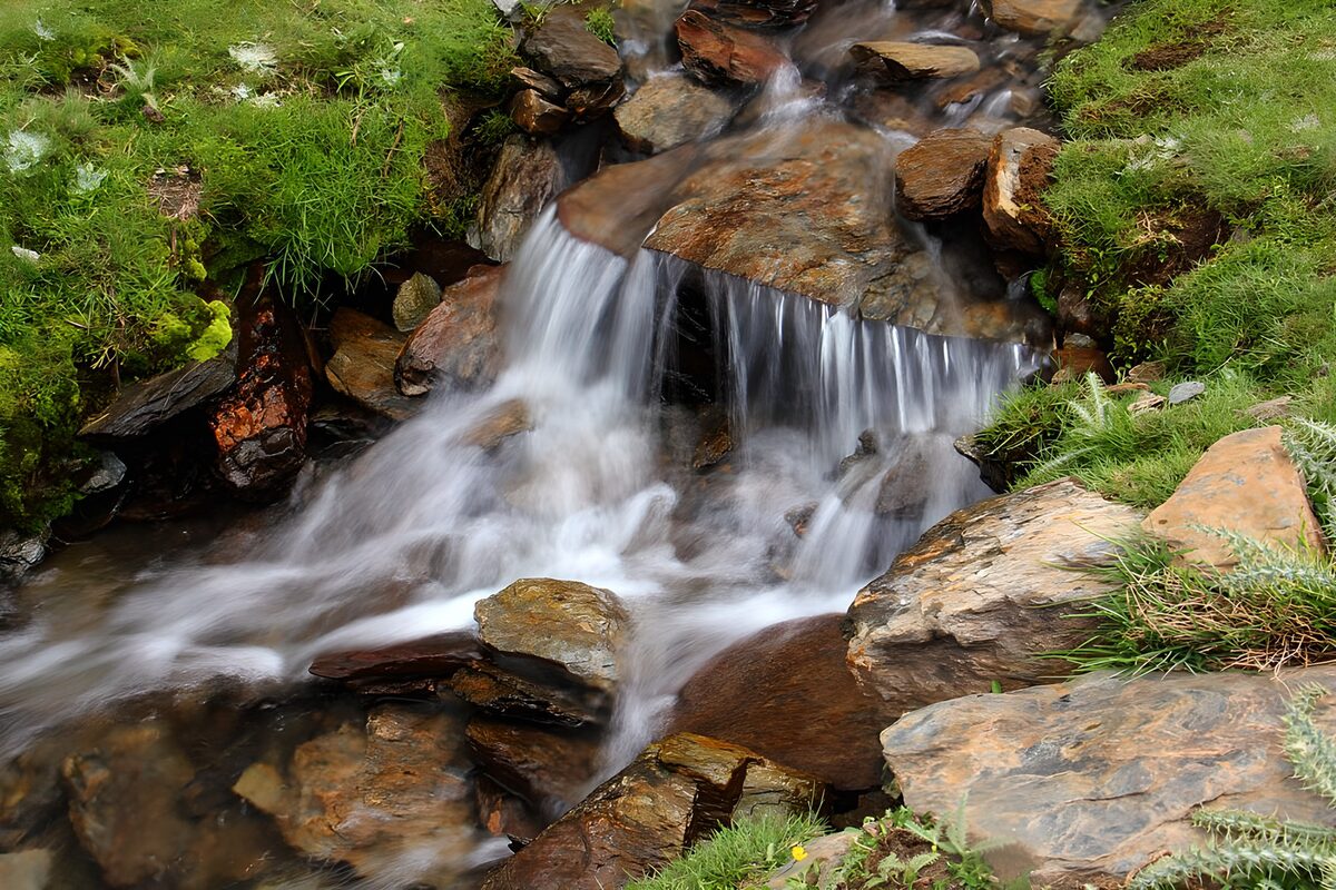 Kleine waterval tussen groene oevers