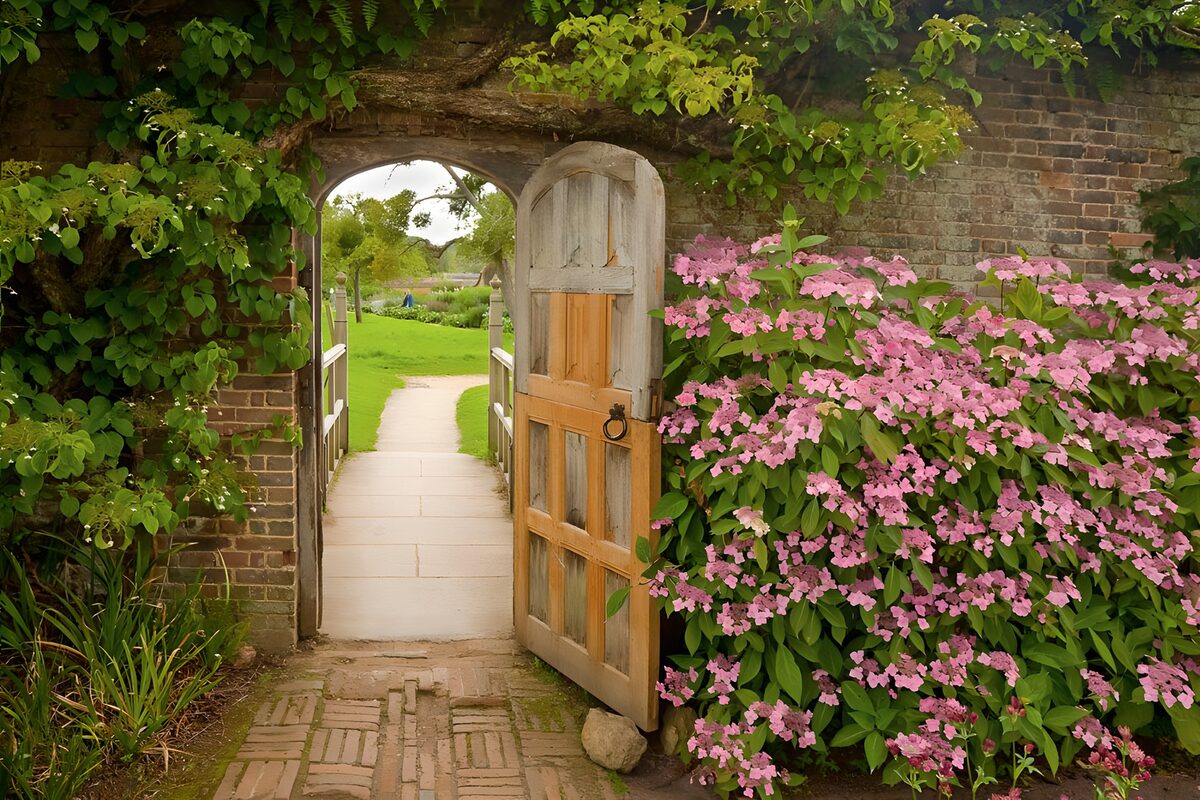 Open houten tuinpoort met roze bloemen