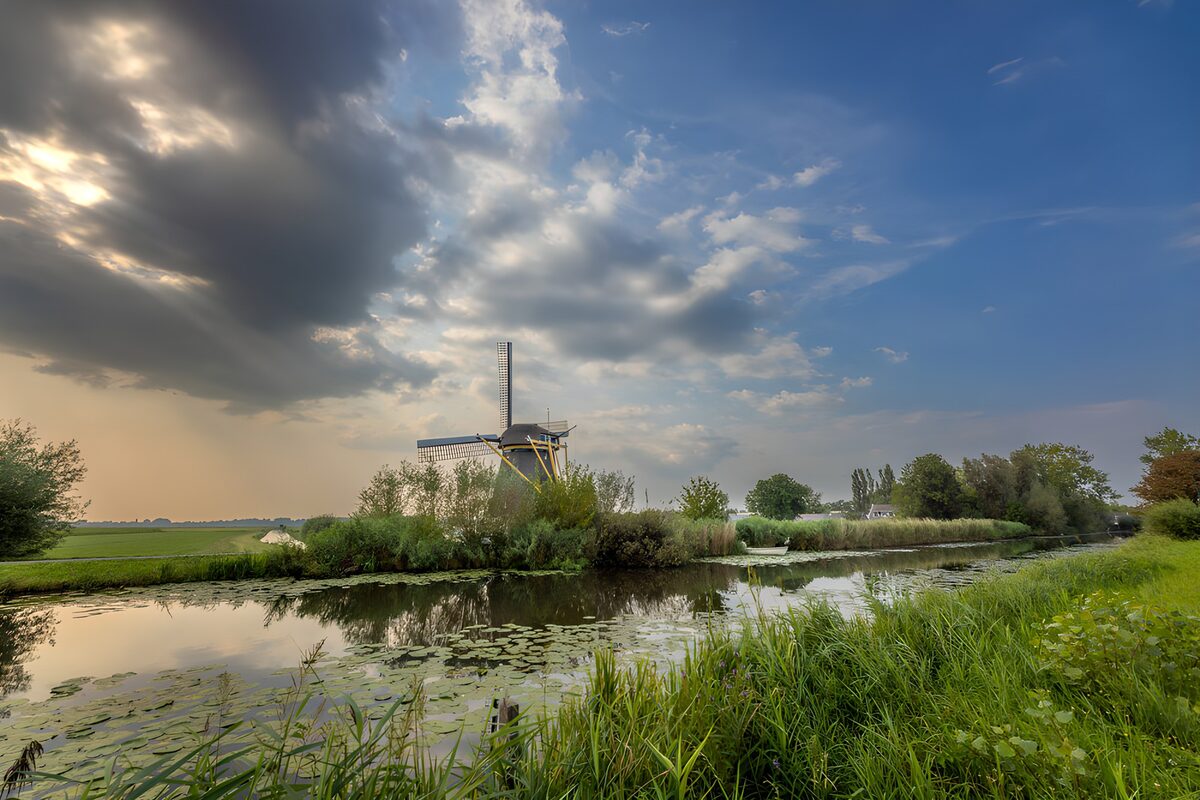 Molen aan het water onder een wolkenlucht