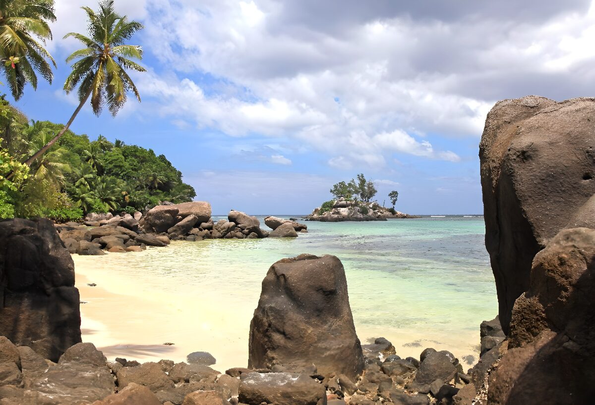 Tropische baai tussen palmen en rotsen