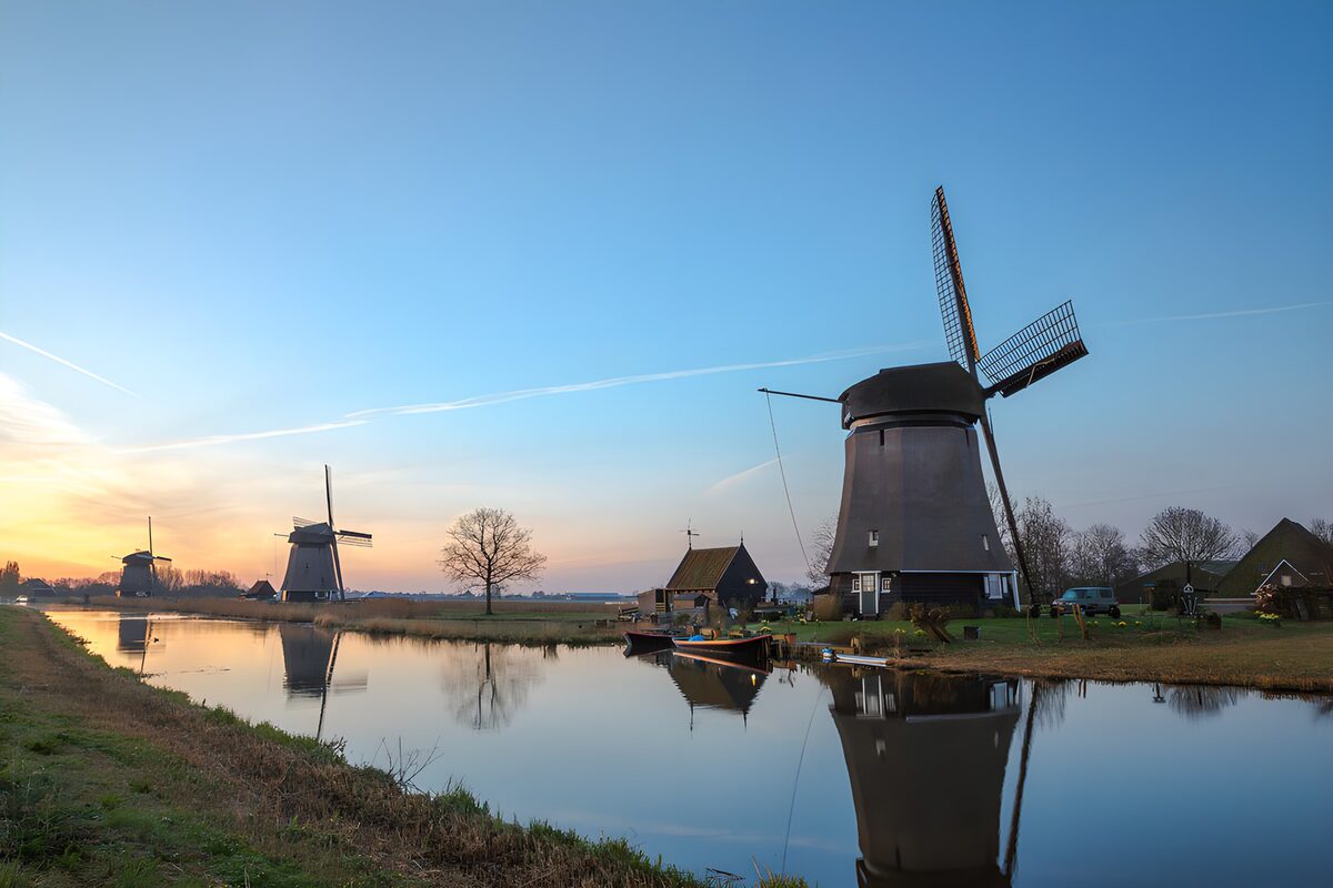 Drie windmolens aan een spiegelgladde vaart