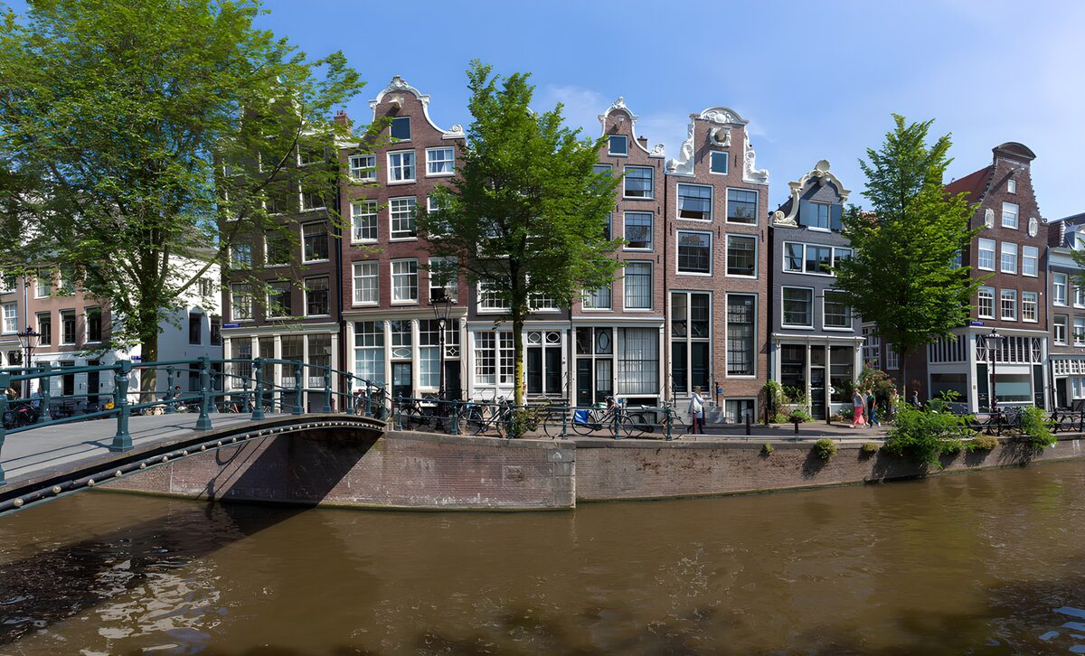 Zonnige gracht met brug en gevels