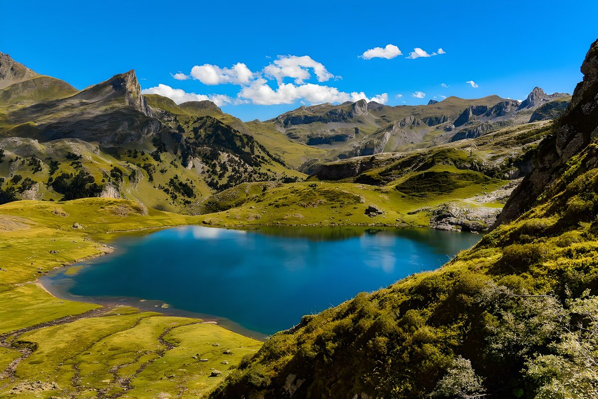 Blauw bergmeer tussen groene hellingen