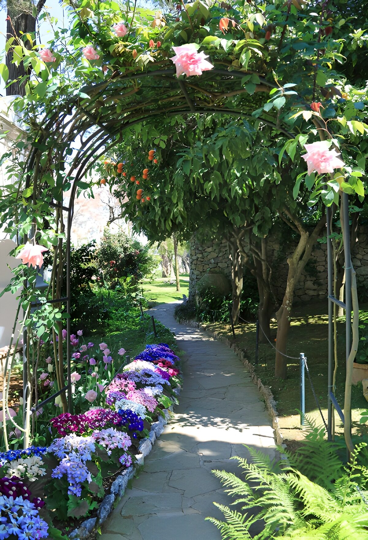 Bloemenboog boven een stenen tuinpad