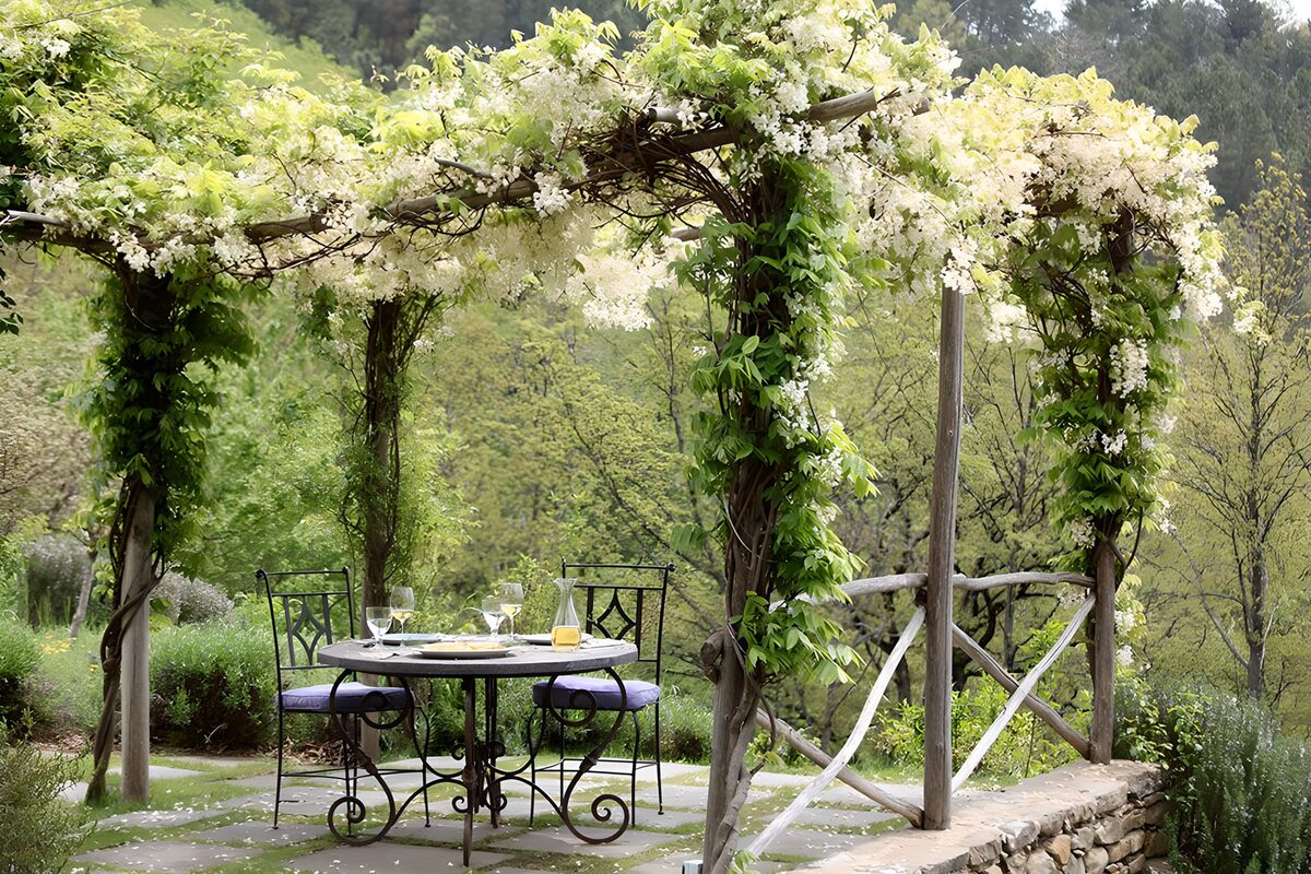 Gedekte tuintafel onder witte bloemen