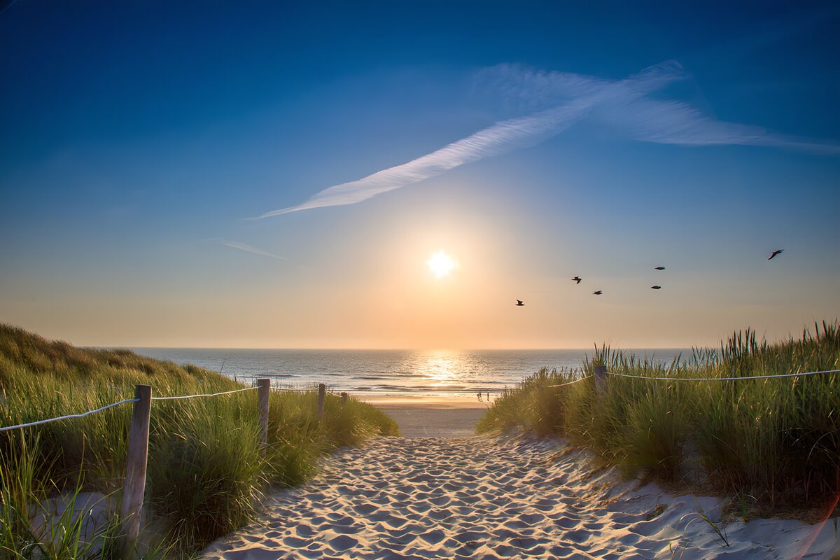Zandpad door de duinen bij zonsondergang