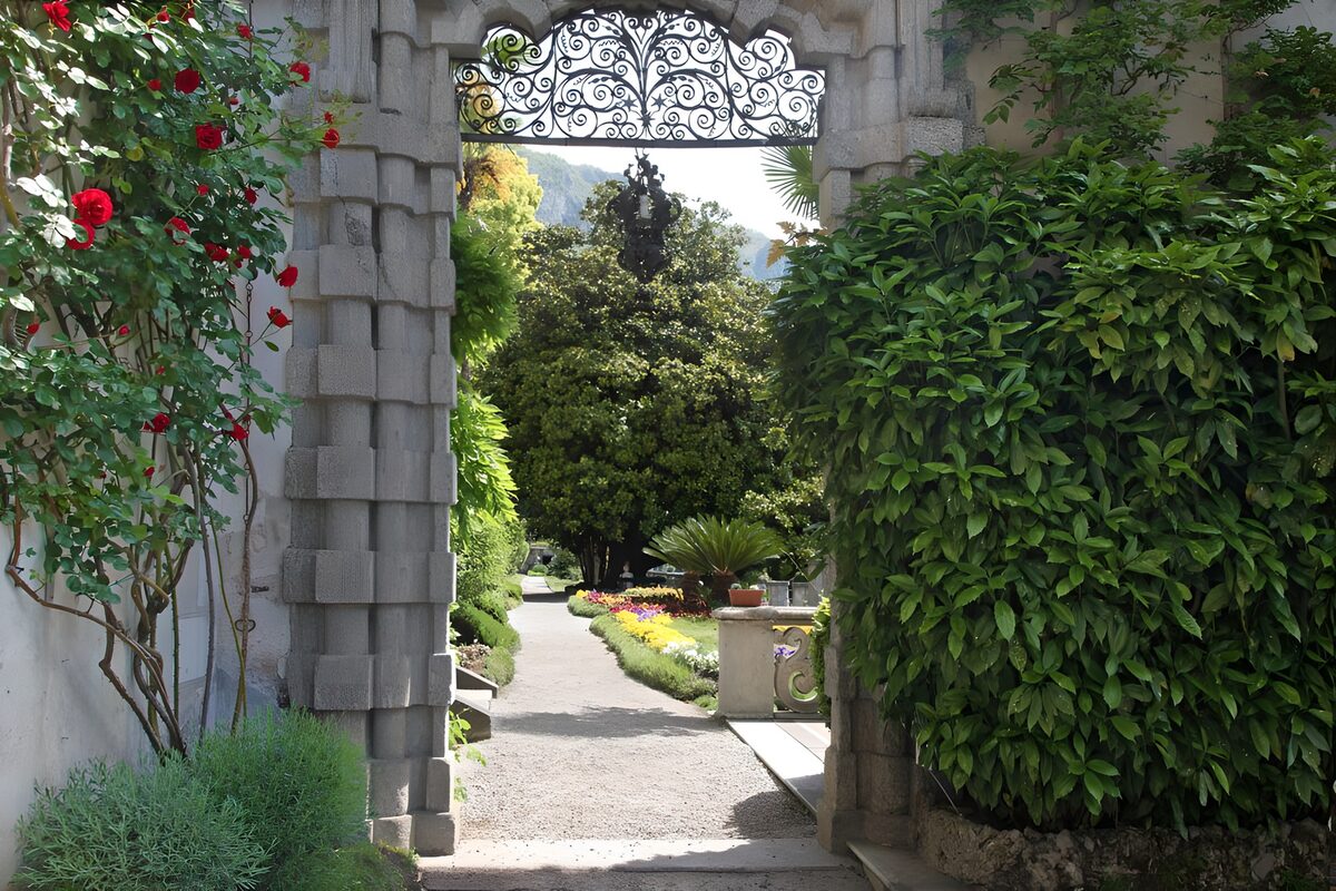 Stenen tuinpoort met rode rozen