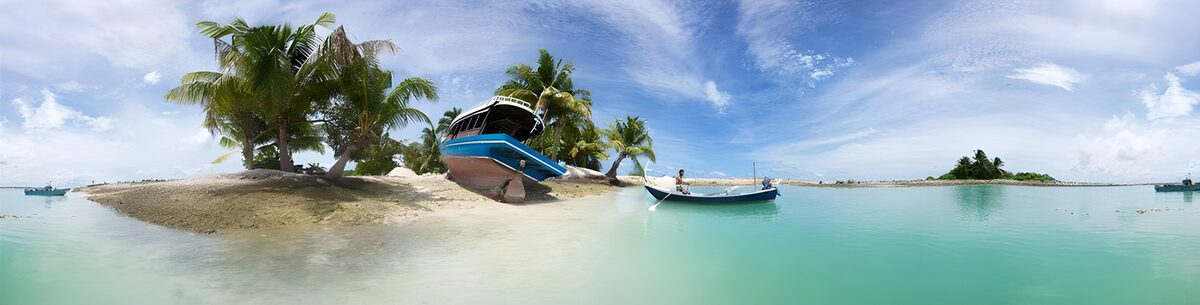 Palmeiland met boten in turquoise water