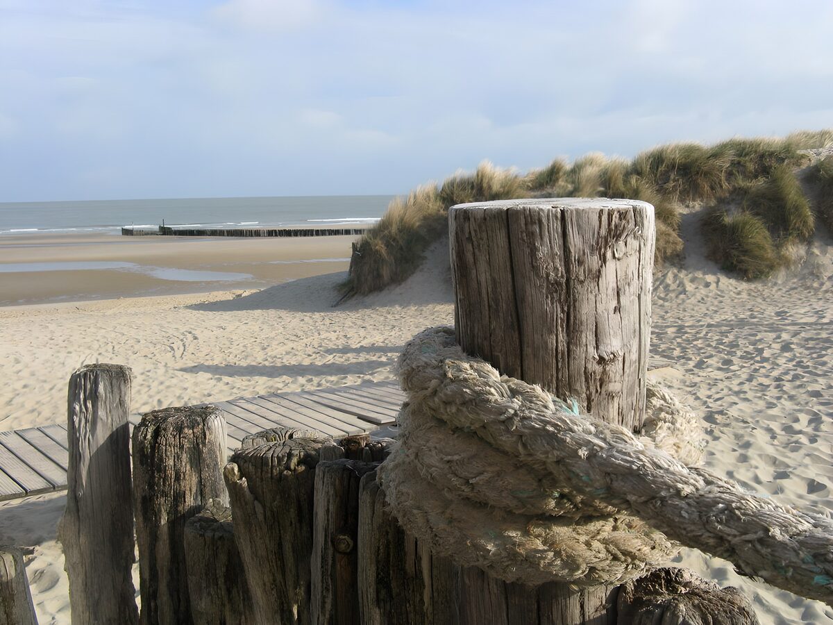 Strand met duinen, palen en touw