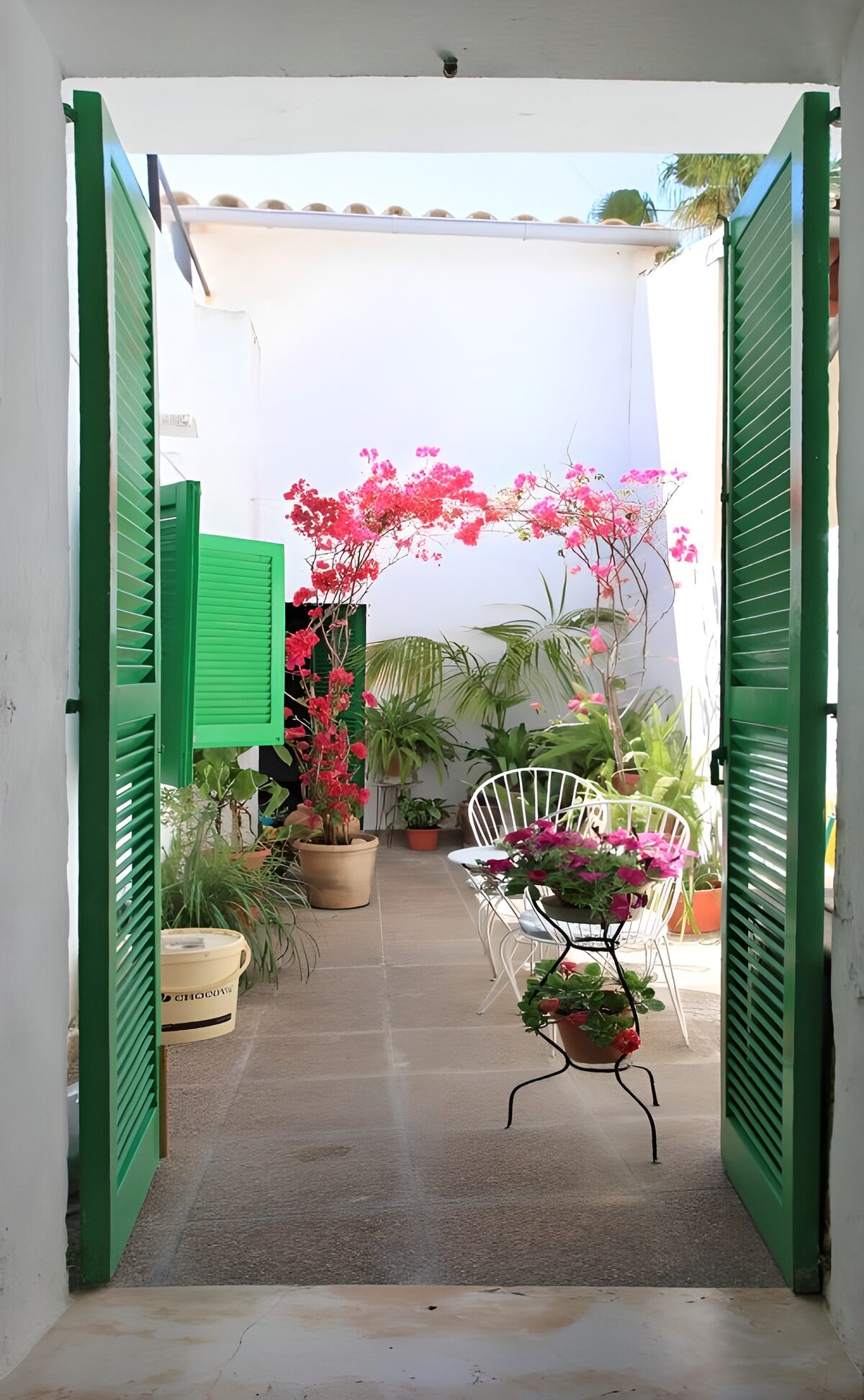 Groene luiken en een patio vol bloemen