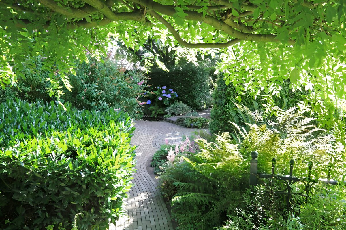 Baksteenpad door een weelderige tuin