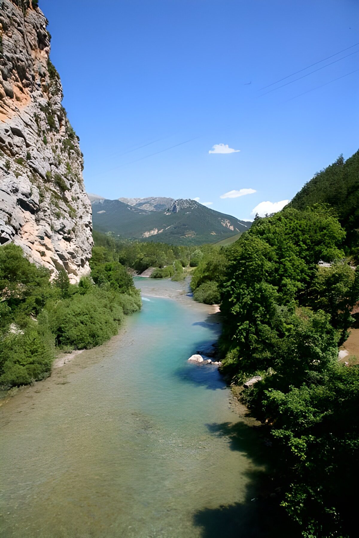 Heldere rivier langs een steile rotswand